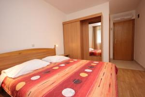ZaglavにあるDouble Room Zaglav 8144dのベッドルーム1室(大型ベッド1台、赤と白の毛布付)