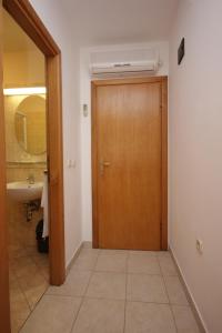 a bathroom with a wooden door and a sink at Double Room Zaglav 8144d in Zaglav