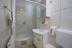a white bathroom with a sink and a shower at Rooms by the sea Hvar - 8785 in Hvar
