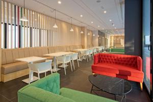 restauracja z czerwoną kanapą, stołami i krzesłami w obiekcie DWO Colours Alcalá w Madrycie