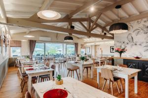 un restaurante con mesas y sillas y una gran ventana en Hotel Restaurant du Fronton, en Itxassou