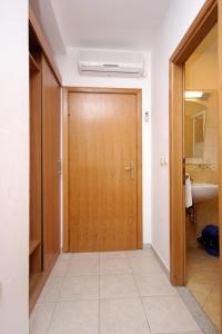 a hallway with a wooden door in a bathroom at Double Room Zaglav 8144e in Zaglav