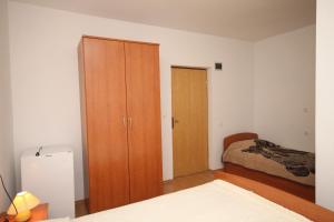 sypialnia z drewnianą szafką i łóżkiem w obiekcie Triple Room Metajna 4120e w mieście Metajna