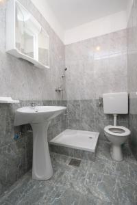 łazienka z umywalką, toaletą i lustrem w obiekcie Triple Room Metajna 4120e w mieście Metajna