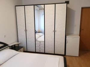a bedroom with a closet with a bed and a mirror at Triple Room Metajna 4120f in Metajna