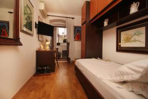 Apartments and rooms with WiFi Makarska - 11063 في ماكارسكا: غرفه فندقيه بسرير ونافذه