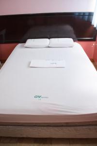 Baybay的住宿－拜拜市GV酒店，一张白色的床,上面有两个枕头