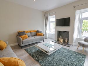 a living room with a couch and a fireplace at 1 Syme Street in Moffat