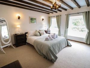 a bedroom with a bed and a large window at Minafon in Oswestry