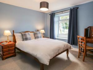 a bedroom with a bed and a window at Roanview Cottage in Askam in Furness