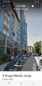 una foto de una calle de la ciudad con coches aparcados en White Apartment, en Tirana
