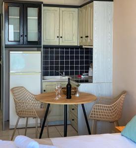 kuchnia ze stołem z kieliszkami do wina i lodówką w obiekcie Sunset Premium Studio 2 w mieście Agios Nikitas