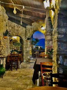 a restaurant with tables and chairs and a stone wall at Hotel Villa Torre Antica in Atena Lucana