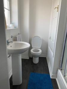 La salle de bains blanche est pourvue d'un lavabo et de toilettes. dans l'établissement Comfortable Stay, 
