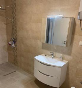 a bathroom with a white sink and a mirror at Strandhaus Roko in Preko +16 photos