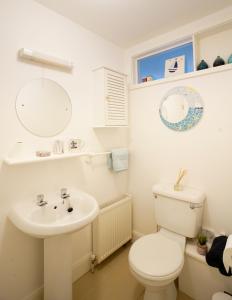 a white bathroom with a toilet and a sink at Stripe Bay in Belmullet