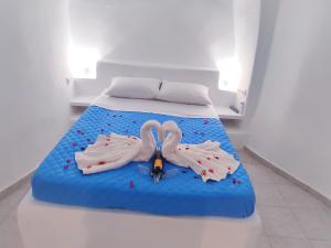 Una cama con dos cisnes en una habitación en EL PATRON SANTORINI en Fira