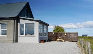 a tiny house with a large window and a fence at Stripe Bay in Belmullet