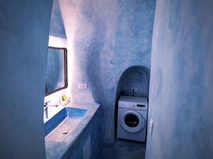 y baño con lavadora y lavamanos. en EL PATRON SANTORINI en Fira