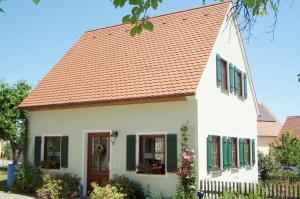 a white house with an orange roof at Top Ferienhaus - Nähe Nürnberg - Schnelles Wlan in Neuendettelsau