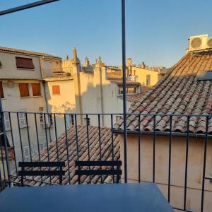 - un balcon avec 2 chaises et des bâtiments dans l'établissement Un balcon sur les toits d'Aix, à Aix-en-Provence