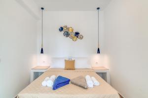 a bedroom with a bed with towels and a clock on the wall at Ippocampos Seaside Serenity - Unwind at Paros Poolside Retreats in Aliki