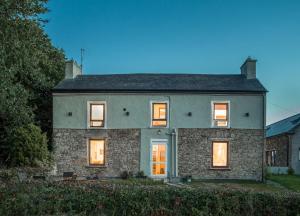 a large stone house with its lights on at Curragh House in Kinsale