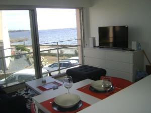 a room with a table with two glasses and a view of the ocean at Votre VUE, La MER, Les Bateaux !!! wir sprechen flieBen deutsch, Touristentipps, we speak English in Concarneau