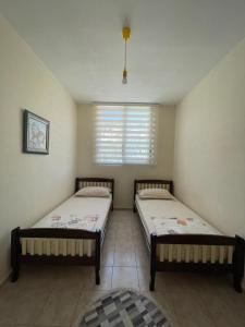 發羅拉的住宿－Lisus Apartment，带窗户的客房内设有两张单人床。