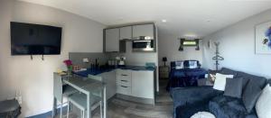 a living room with a blue couch and a table at Little bay cabin in Oban