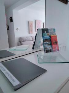 een bureau met een laptop en boeken erop bij Piso luminoso cerca de playa in Cádiz