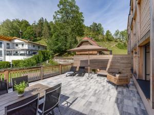 a patio with a table and chairs and an umbrella at Apartment Hideaway - Stylisch, ruhig, Topausstattung, Infrarotsauna, Dachterrasse in Walchsee