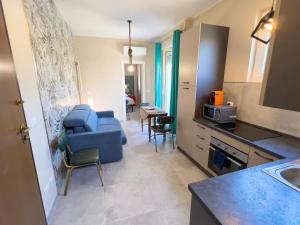 eine Küche und ein Wohnzimmer mit einem blauen Stuhl in der Unterkunft Appartamento Due in Diano Marina