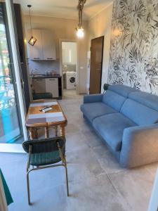 ein Wohnzimmer mit einem blauen Sofa und einem Tisch in der Unterkunft Appartamento Due in Diano Marina