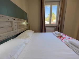 Schlafzimmer mit einem großen weißen Bett und einem Fenster in der Unterkunft Appartamento Due in Diano Marina