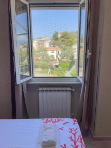 Schlafzimmer mit einem Bett und einem Fenster mit Aussicht in der Unterkunft Appartamento Due in Diano Marina