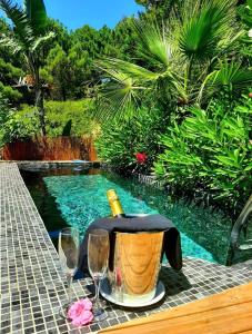 una mesa con una botella de vino y copas junto a una piscina en DDG Retreat, en Casares