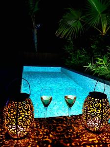 two glasses of wine sitting on a table next to a pool at DDG Retreat in Casares