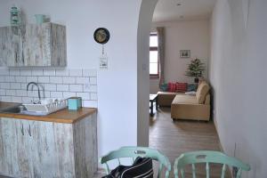 a kitchen and a living room with a counter and chairs at Apartamenty Stacja Kasina in Kasina Wielka