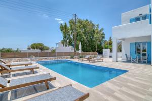 een villa met een zwembad en een patio bij Ippocampos Seaside Serenity - Unwind at Paros Poolside Retreats in Aliki