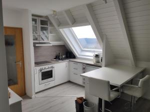 a kitchen with white cabinets and a large window at Bollenhut Superior in Lenzkirch