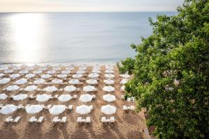 einen Blick über den Strand mit Stühlen und Sonnenschirmen in der Unterkunft Astoria Hotel All Inclusive & Private Beach in Goldstrand
