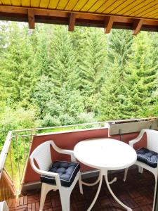 a balcony with a table and chairs and trees at Bollenhut Superior in Lenzkirch