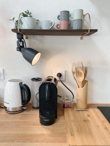 a kitchen counter with a coffee maker and cups on a shelf at Bonnieux : Loft - La pause in Bonnieux