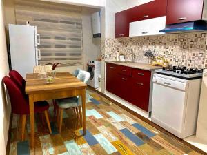 a kitchen with a wooden table and red cabinets at JAZZY TOP CLASS 3 BEDROOMS HOMES 100Mb Wi-Fi in Antalya