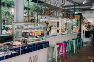 a bar with green and pink stools at Stayokay Hostel Amsterdam Vondelpark in Amsterdam +37 photos