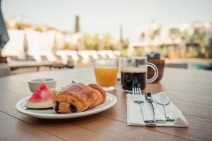 a plate of food with a pastry and a drink at Van der Valk Hotel Bloom Saint Aygulf in Saint-Aygulf