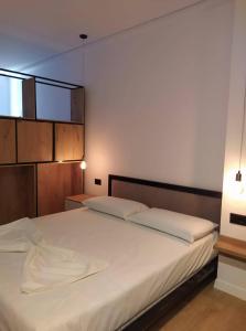 una camera da letto con un grande letto bianco con due lampade di Apartament Stefani a Sarandë