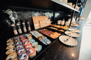 a buffet line with plates and bowls of food at Van der Valk Hotel Bloom Saint Aygulf in Saint-Aygulf