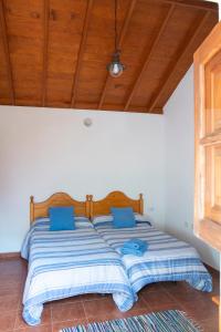 a large bed with blue pillows in a bedroom at CR las Nuevitas Tranquilidad y Descanso in Hermigua